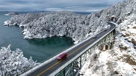Static-aerial-shot-of-vehicles-passing-over-Deception-Pass-bridge-in-the-snow