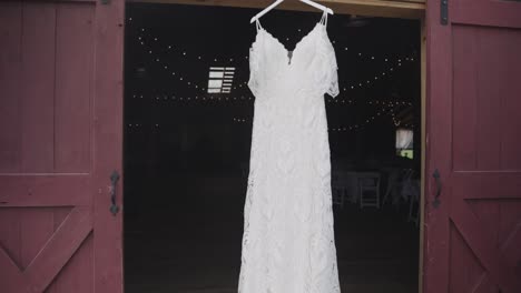 Weißes-Hochzeitskleid,-Das-Vor-Der-Zeremonie-Zwischen-Rustikalen-Scheunentoren-Hängt
