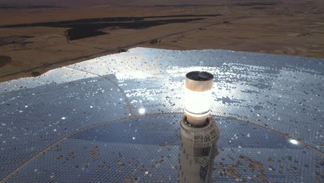Tallest-solar-power-tower-in-the-world-close-up-view,-desolate-desert-in-the-background---aerial-drone-shot
