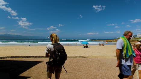 Panning-shot-at-popular-Central-Beach-seafront-with-beachgoers,-Plettenberg-Bay