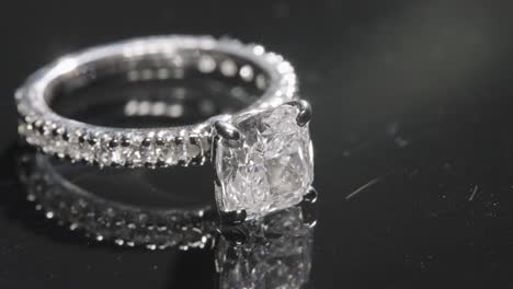 Close-up-of-luxurious-diamond-engagement-ring-rotating-on-a-glass-table