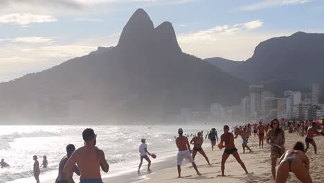 Eine-Menge-Brasilianischer-Einheimischer,-Die-An-Einem-Sommertag-Frescobol-Am-Strand-Von-Copacabana-Spielen