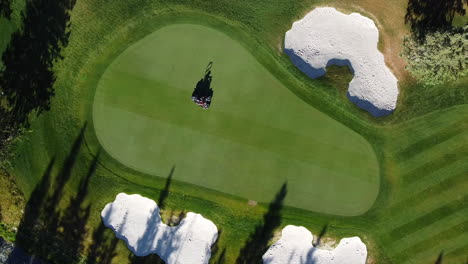 Drone-shot-of-green-golf-course-in-the-rocky-mountains-of-Banff-and-Kananaskis-of-Alberta,-Canada-straight-down