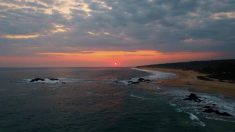 Aerial-view-of-a-warm-sunset-over-the-beaches-of-Puerto-Escondido,-Mexico
