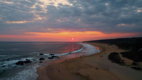 Obenliegende-Aufnahme-Von-Puerto-Escondido-Mit-Menschen-Am-Strand-Und-Im-Meer-Während-Des-Sonnenuntergangs
