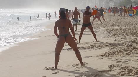 Two-friend-couples-playing-frescobol-on-Copacabana-beach-on-a-hot-summer-day