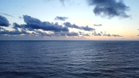 Drone-shot-calm-blue-ocean-water-at-sunset