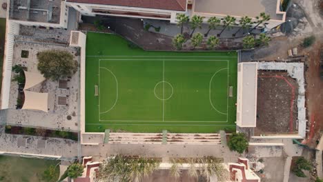 Lowering-aerial-shot-of-a-soccer-pitch-in-Spain-on-a-warm-summer-day