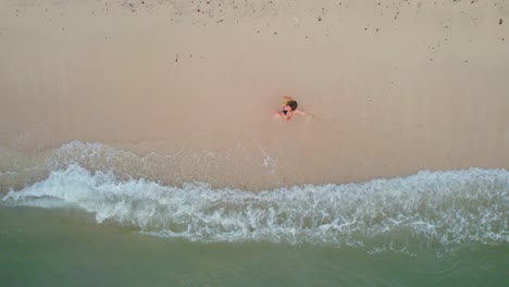 Topdown-shot-of-a-young-beautiful-woman-walking-along-the-tropical-beach-of-Cozumel