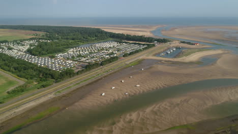 Establishing-Drone-Shot-of-Wells-Next-The-Sea-Static-Caravan-Holiday-Home-Park-with-Creek-at-Low-Tide-and-Sandy-Beach