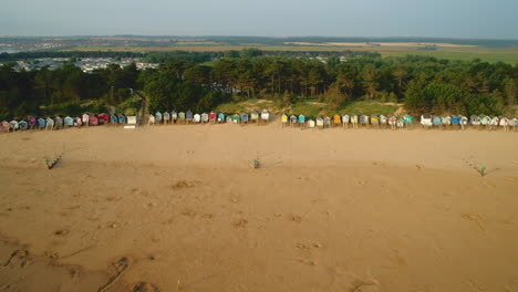 Drone-Shot-Pulling-Back-from-Beach-Huts-infront-of-Woodland-Area-with-Beach-and-Sea-in-Wells-Next-The-Sea-North-Norfolk-UK-East-Coast