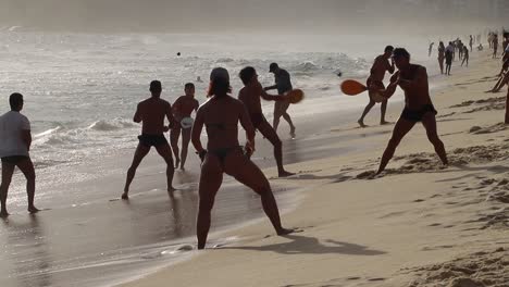 Gruppen-Von-Menschen,-Die-Am-Weihnachtstag-Frescobol-Am-Copacabana-strand-Spielen