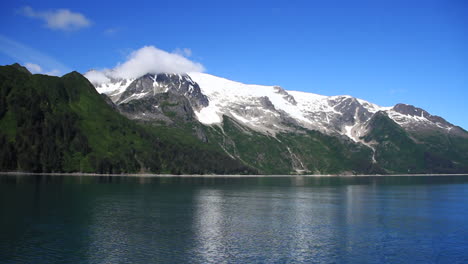 Hermoso-Océano-Azul-Pasa-Frente-A-Montañas-Y-Nubes-Cubiertas-De-Nieve