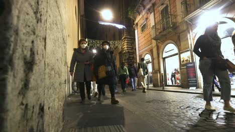 Street-at-night-in-Rome,-Italy-with-people-walking