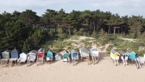 Beach-Huts-on-Sandy-Beach-with-Woodland-Behind-Dolly-Tracking-Slider-Drone-Shot-in-Wells-Next-The-Sea-North-Norfolk-UK