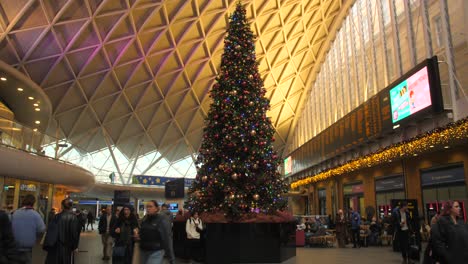 Impressive-Christmas-Tree-Inside-The-King's-Cross-Railway-Station-In-London-With-Travellers-Walking-By