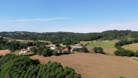 Aerial-Of-Idyllic-Village-In-Countryside-Plain-Surrounded-By-Vegetations
