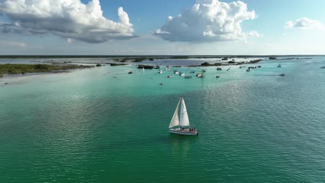 Aerial-view-around-a-sailboat-on-the-laguna-Bacalar,-in-Mexico---orbit,-drone-shot