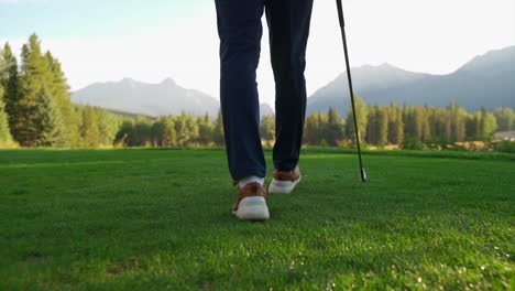 Golfer-walking-in-green-golf-course-in-the-rocky-mountains-of-Banff-and-Kananaskis-of-Alberta,-Canada