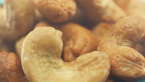 A-macro-close-up-shot-of-a-roasted-salty-cashew-bawl-on-a-rotating-stand,-slow-motion,-4k