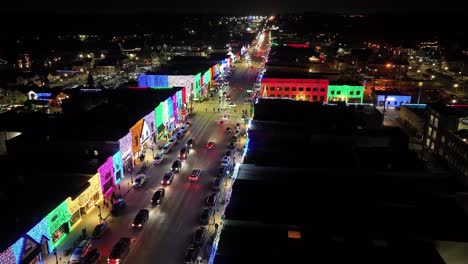 Rochester,-Michigan-skyline-at-night-lit-up-with-Christmas-lights-on-buildings-and-drone-video-moving-forward