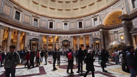 People-inside-the-Pantheon-in-Rome,-Italy-with-video-tilting-up-to-dome