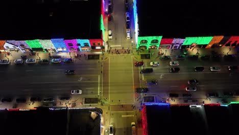 Rochester,-Michigan-skyline-at-night-lit-up-with-Christmas-lights-on-buildings-and-drone-video-pulling-up