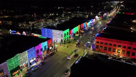 Rochester,-Michigan-skyline-at-night-lit-up-with-Christmas-lights-on-buildings-and-drone-video-circling-close-up
