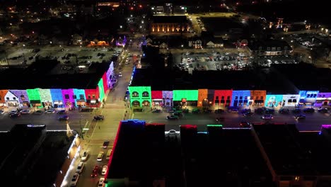 Rochester,-Michigan-skyline-at-night-lit-up-with-Christmas-lights-on-buildings-and-drone-video-moving-sideways