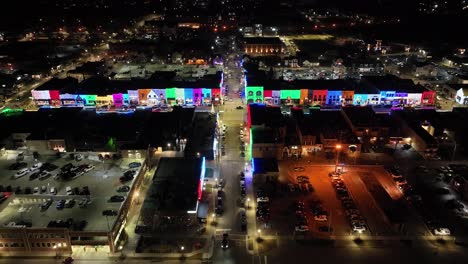 Rochester,-Michigan-skyline-at-night-lit-up-with-Christmas-lights-on-buildings-and-drone-video-wide-shot-moving-forward