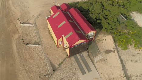 Rotating-Drone-Shot-Around-Old-Lifeboat-Station-on-Sandy-Beach-in-Wells-Next-The-Sea-North-Norfolk-UK-East-Coast
