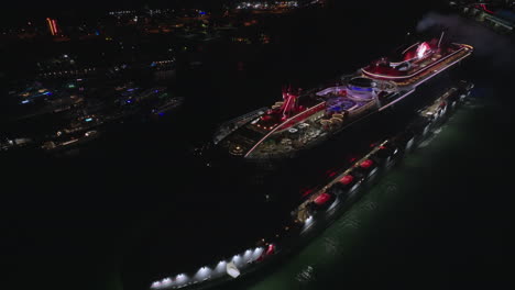 Gran-Crucero-Iluminado-Por-Luces-De-Neón-Estacionándose-En-El-Puerto-De-Miami-Por-La-Noche