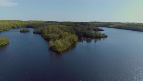 Aerial-of-a-lake-with-remote-forested-islands-in-the-middle-of-the-woods