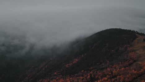 Zeitraffer-Von-Sich-Bewegenden-Wolken,-Nebel-Und-Nebel,-Die-In-Der-Herbstsaison-über-Die-Spitze-Eines-Berges-Kommen