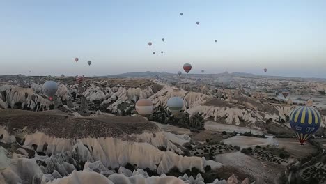 Luftaufnahme-Von-Ballons,-Die-Bei-Sonnenaufgang-In-Göreme,-Kappadokien,-Fliegen