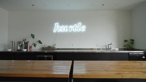 Neon-light-sign-decoration-that-says-hustle-in-an-office-kitchen