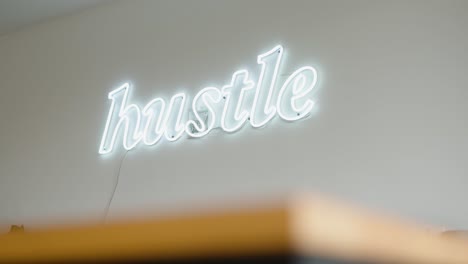 Hustle-neon-light-sign-decoration-hung-in-an-office