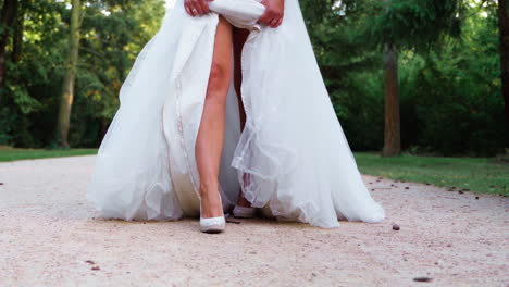Slow-motion-footage-of-a-sexy-bride's-legs-walking-in-a-park-toward-the-camera