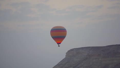 Blauer-Und-Rosafarbener-Orangefarbener-Ballon,-Der-über-Das-Göreme-Tal-In-Kappadokien-Fliegt