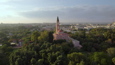 Russian-Orthodox-Church-at-sunset-time-surrounded-by-trees-and-lawns---drone-shot