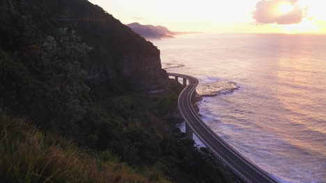 Sea-Cliff-Bridge-Epischer-Sonnenaufgang-Sonnenuntergang-Fahren-über-Den-Ozean-Australien-Atemberaubende-Küste-TV-Werbematerial-Drohne-Von-Taylor-Brant-Film
