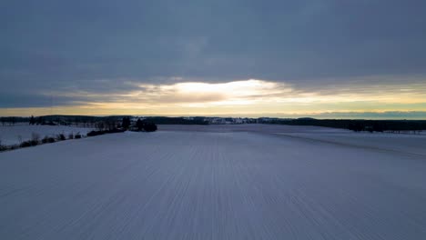 Snow-covered-farm-in-London,-Canada,-farm-landscape-with-aerial-drone-view-60fps,-sunrise-and-clouds-trees-and-houses