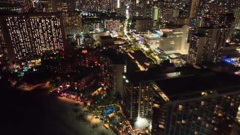 30-fps-pan-up-of-waikiki-strip-and-skyline-at-night-with-traffic-palm-trees-traffic-in-honolulu-oahu-hawaii-on-beach