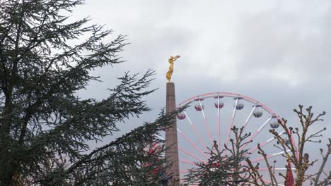 Ferris-wheel-next-to-Golden-Lady-statue-in-Christmas-time-in-city-centre-of-Luxembourg---from-distant