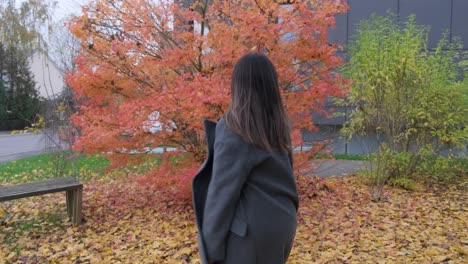 Girl-walking-and-dancing-at-fall-season-over-leaves