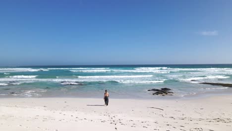 Mädchen-Zu-Fuß-Zum-Meer-über-Den-Weißen-Sand-Des-Südafrikanischen-Strandes---Luftaufnahme