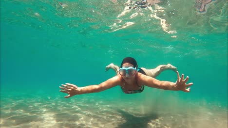 Woman-swimming-in-shallow-tropical-water-with-goggles