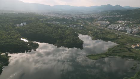 Aerial-shot-of-Grand-Park-of-Tirana-with-clouds-mirroring-in-lake