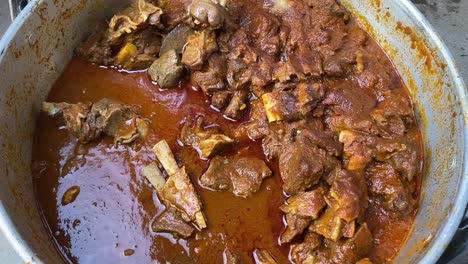 Close-up-shot-of-delicious-mutton-curry-dish-in-aa-steel-bowl-during-an-Indian-function