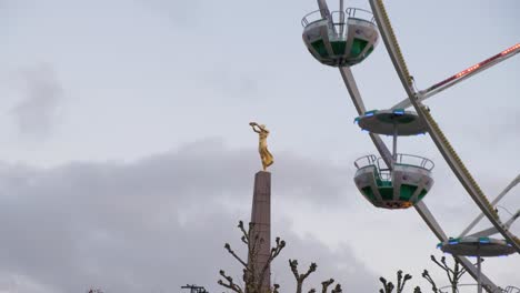 Ferris-wheel-next-to-Golden-Lady-statue-in-Christmas-time-in-city-centre-of-Luxembourg